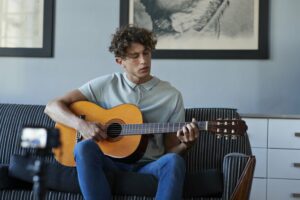 Young man teaching a guitar class online