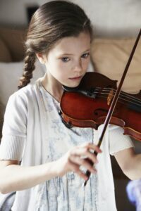 Little girl with braided hair playing the violin
