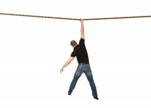 Man hanging from a rop against a white background