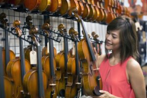 Woman holding a violin at the music store