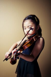 Little girl practicing playing the violin