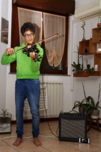 Man in a green sweater playing the electric violin