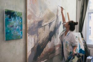 Female artist applying paint to her painting with a paint brush