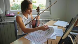 Woman flipping through sheet music while practicing violin