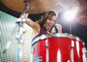 Young woman playing a drum set on stage
