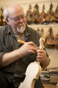 Older man building a violin