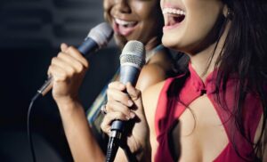 Two young women singing karaoke together