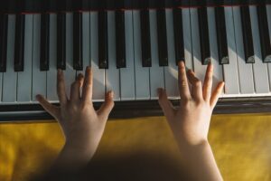 Close up of top view of a child's hands playing the piano