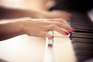 Woman's manicured hands playing the piano