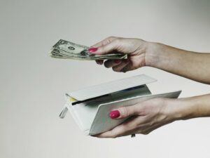 Close up of manicured hands paying with cash