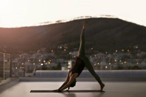 Woman on a rooftop doing inverted yoga