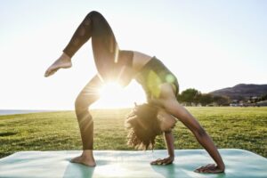 Young woman doing inverted yoga as the sun rises