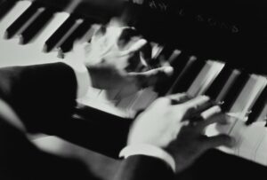 Black and white picture of a man's hands playing the piano
