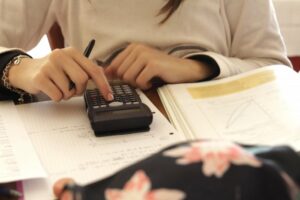 Close up of a teen girl doing her math homework with a calculator