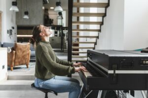 Woman in a green sweater playing the piano