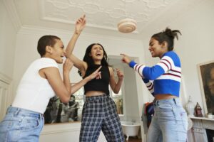 Three girls singing together in living room