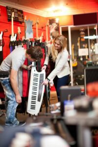 Young couple checking out a keytar in a music store