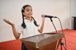 Little girl in braids speaking at a podium
