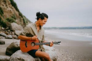 Man playing the acoustic guitar on the beach