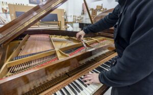 Close up of a piano tuner working on a piano