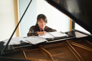 Young woman writing a song for piano part