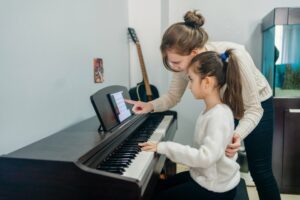 Piano teacher helping female student