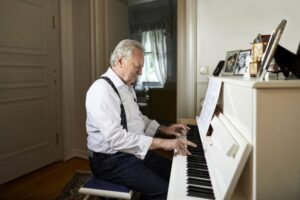 Senior citizen playing a white piano