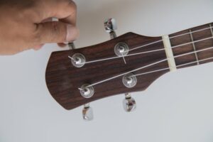 Closeup of a hand turning the tuning pegs