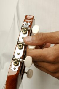 Closeup of a hand tuning a guitar