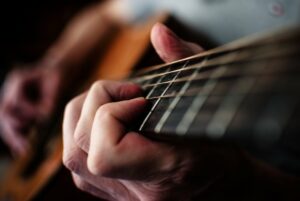 Close up of man's hand playing guitar