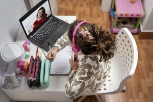 Little girl sitting at her desk learning remotely