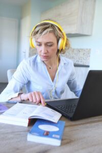 Woman with yellow headphones studying a new language online 