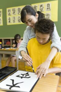 Female instructor showing a student how to write a Japanese character