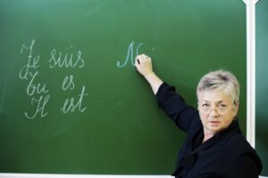 Female instructor writing French words on a chalkboard