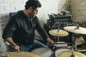 Man wearing glasses playing the drums