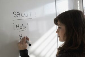 Teen girl writing Spanish words on a white board