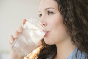 Woman drinking a glass of ice water