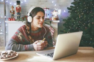 Young woman listening to music on her laptop during Christmas