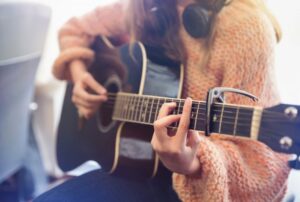 Close up of a woman playing an acoustic guitar