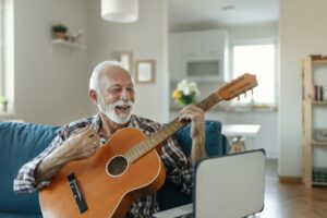 Older man smiling learning to play the guitar
