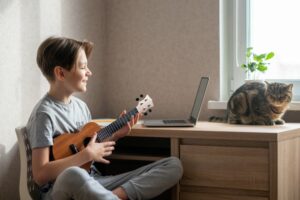 Little boy learning to play ukulele online
