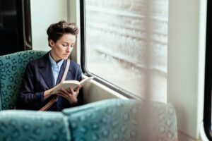 Mature business woman reading a book on a train