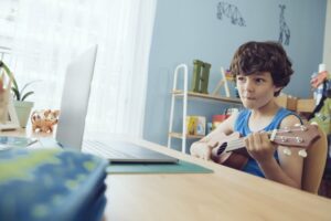 Little boy learning to play the ukulele online