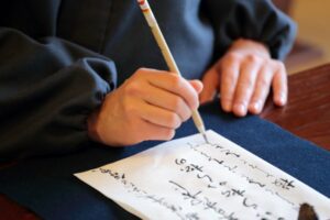 Close up of a man writing in Japanese