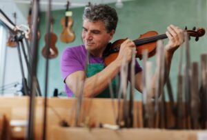 A man repairing a violin in a music store