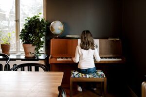 Back view of a little girl playing the piano