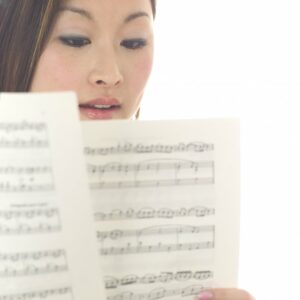 Close up of a woman's face while she is reading sheet music