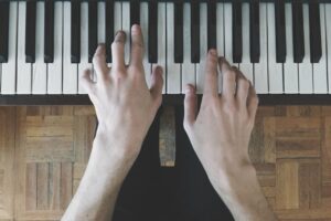 Close up top view of hands playing the piano
