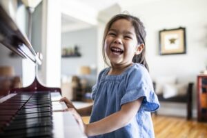 Little girl laughing playing the piano