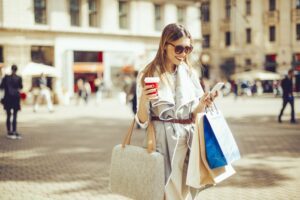 Business woman walking through a plaza with shopping bags